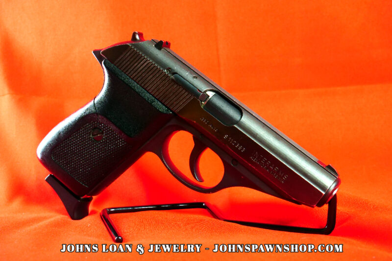Sig Sauer P230 pistol chambered in .380 ACP, showcased on a black stand against an orange backdrop, offered by John's Loan & Jewelry as a perfect CCW nightstand gun.
