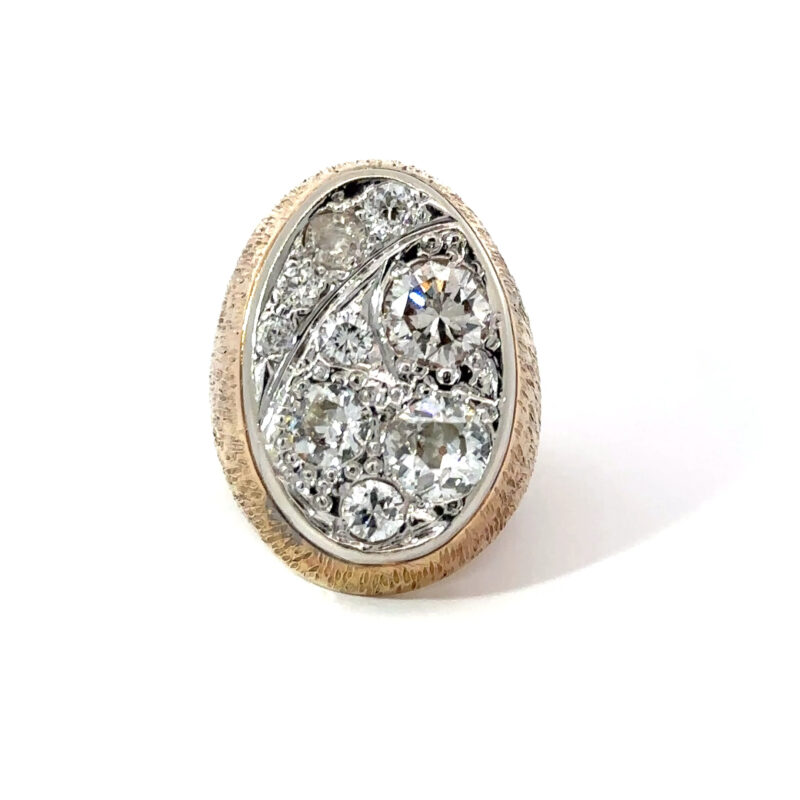 Close-up of a John's Loan & Jewelry men's pinky ring featuring a 14k yellow gold band with a 'Starry Night' diamond cluster setting on a white table.