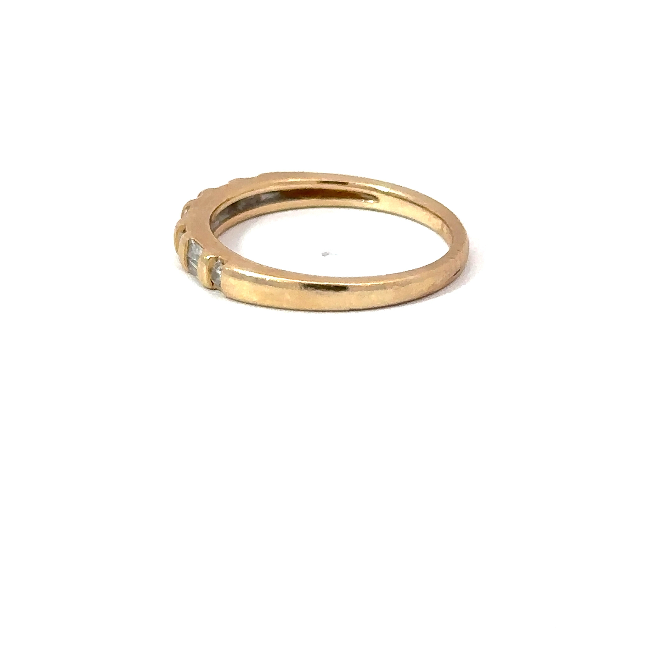 Side-profile view of a 14kt yellow gold ring from John's Loan & Jewelry, showing the diamond stacker band's smooth, polished gold and the recessed setting for the diamonds.